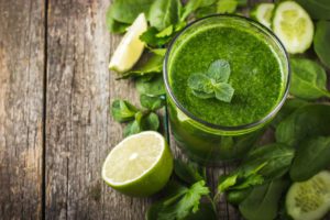 fresh green smoothie with ingredients on rustic background, top view